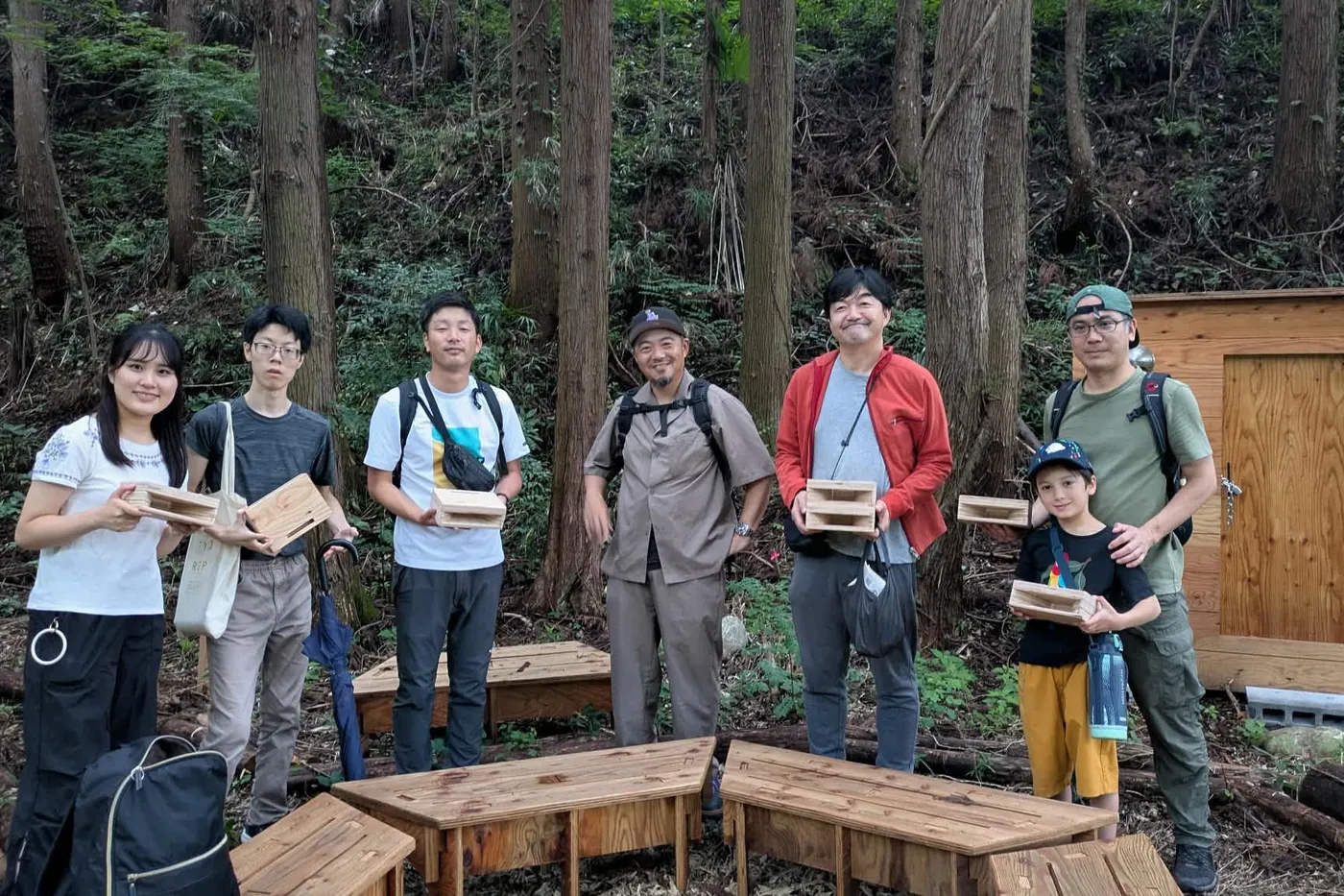 MORIGAWAの森の中で、自作の木製スピーカーを手にした参加者の集合写真